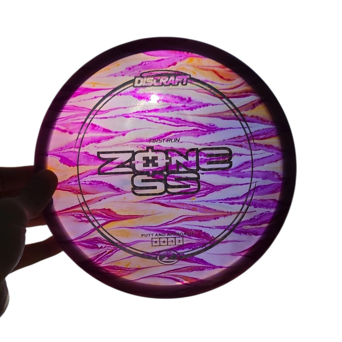 Backlit view of purple and orange hand-dyed Discraft First Run Zone SS in Z plastic