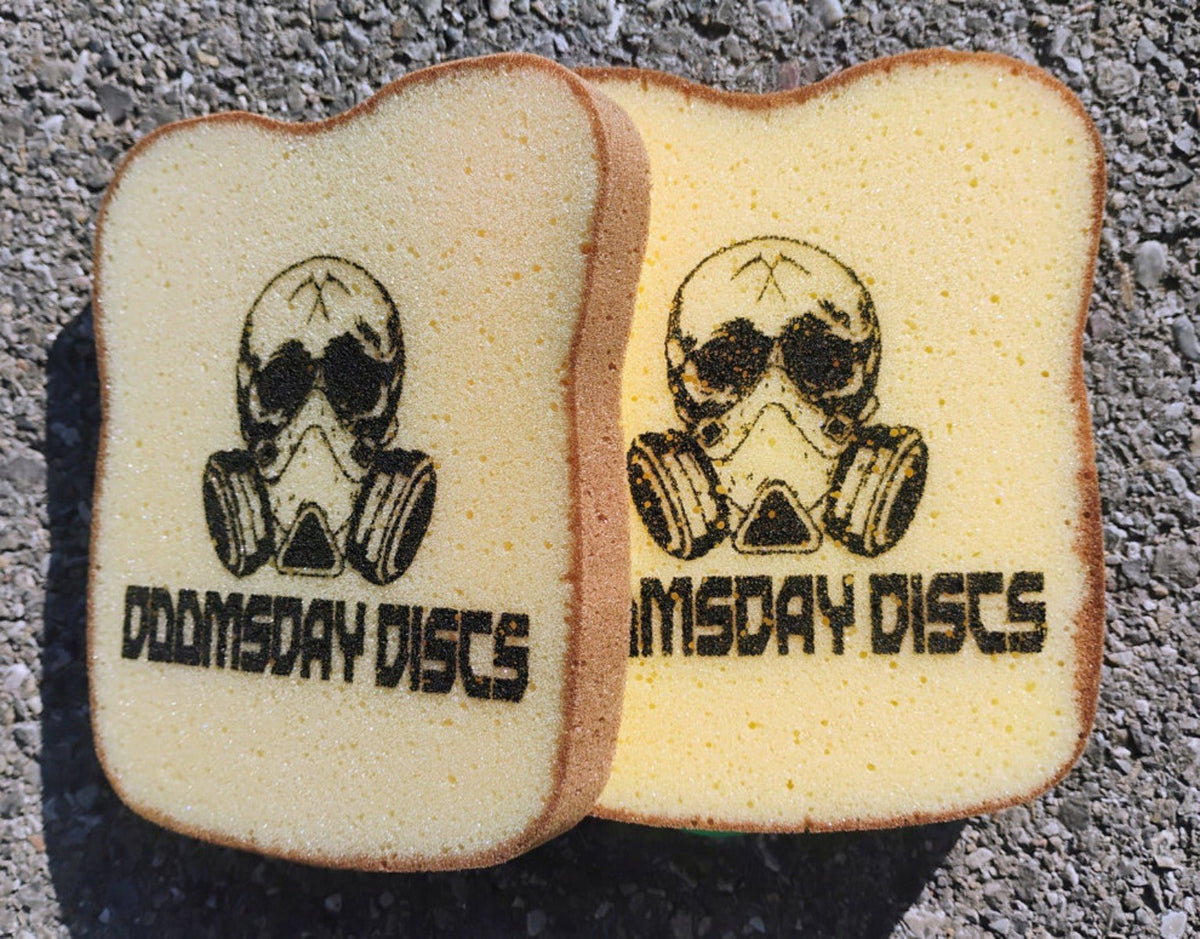Two bread-shaped sponges with black Doomsday Discs logos included in the Cheese Sandwich Edition set