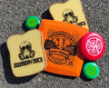 Complete Oxymoron Cheese Sandwich Edition set with orange Survival Sharp Cheddar disc, two bread sponges, two green pickle minis, and one red tomato mini